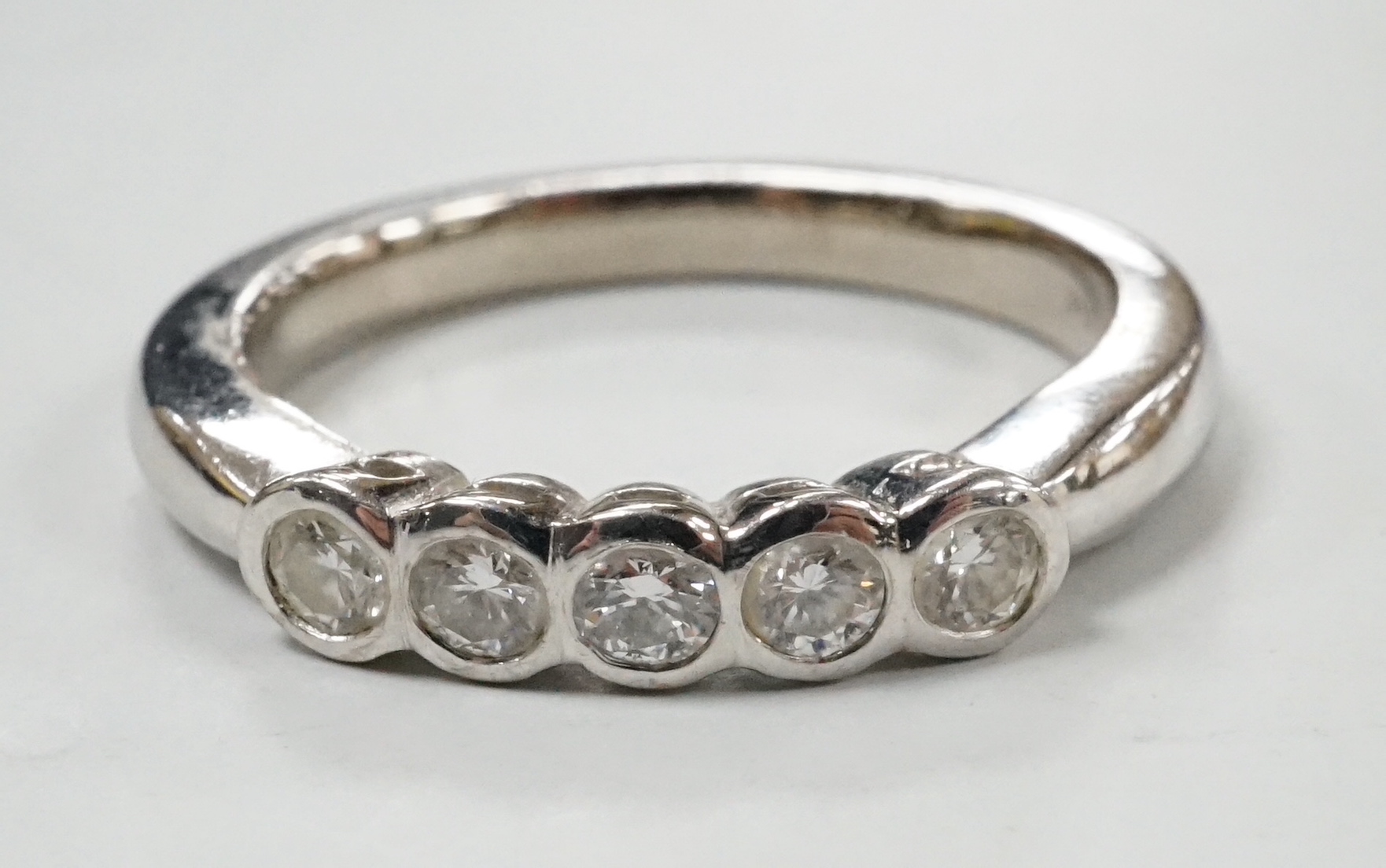 A modern 18ct white gold and five stone collet set diamond ring, size M, gross weight 5 grams.